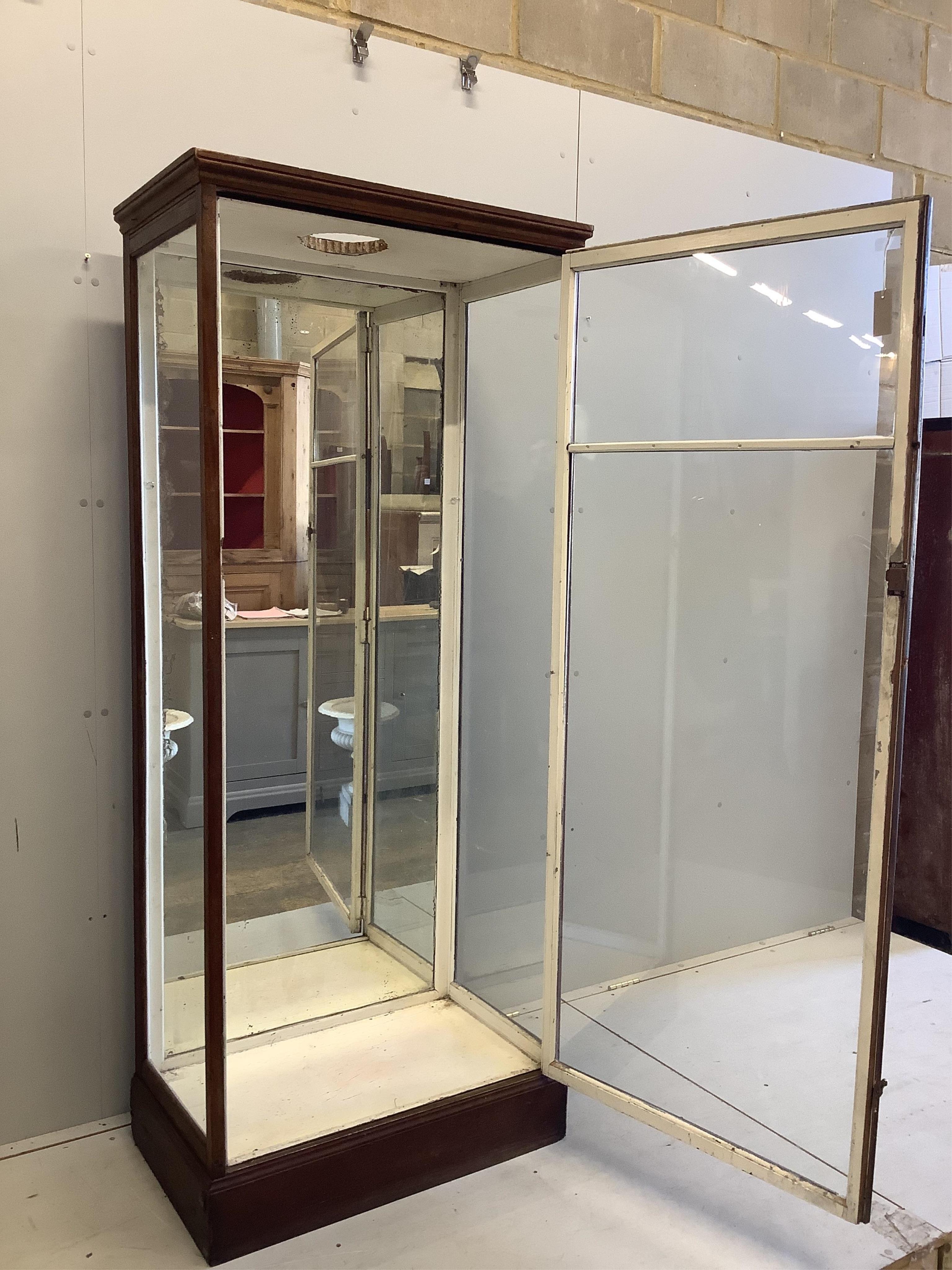 An early 20th century mirrored oak shop display cabinet, width 80cm, depth 47cm, height 189cm. Condition - poor, top has been cut to accommodate a light, lacks glass shelving